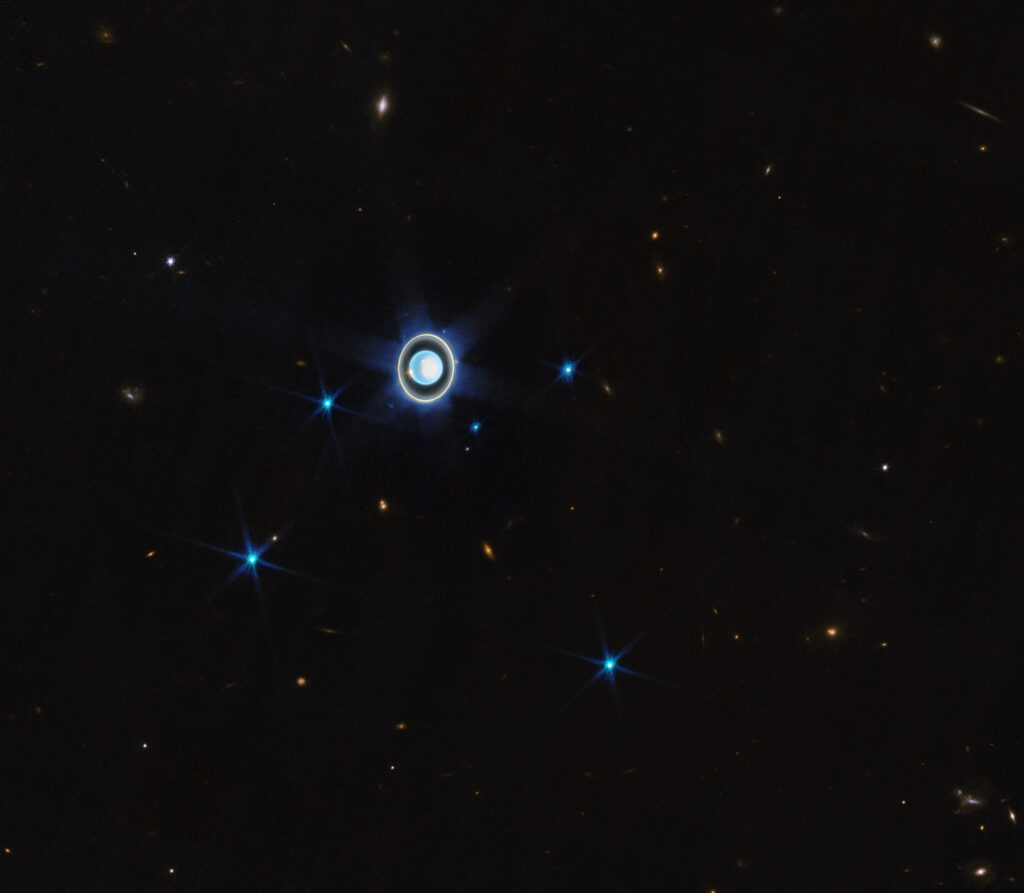 Uran, jego 6 (spośród 27 dotychczas odkrytych) księżyców oraz wiele galaktyk w tle. Zdjęcie wykonane z teleskopu Webba; zdjęcie: NASA, ESA, CSA, STScI, J. DePasquale (STScI)
