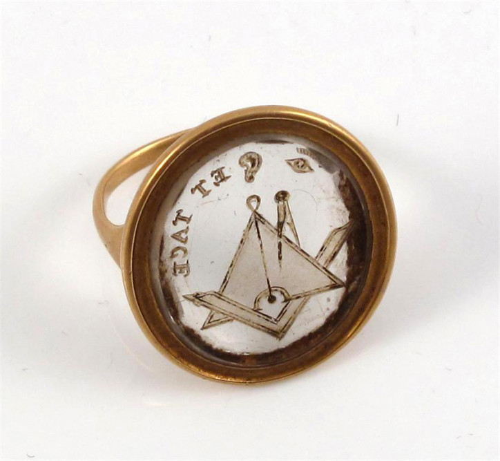 Złoty pierścionek pochodzący z okresu panowania Jerzego III, ozdobiony owalnym kryształem górskim, z wygrawerowanymi emblematami masońskimi i mottem "ET TACE"; zdjęcie: Woolley and Wallis