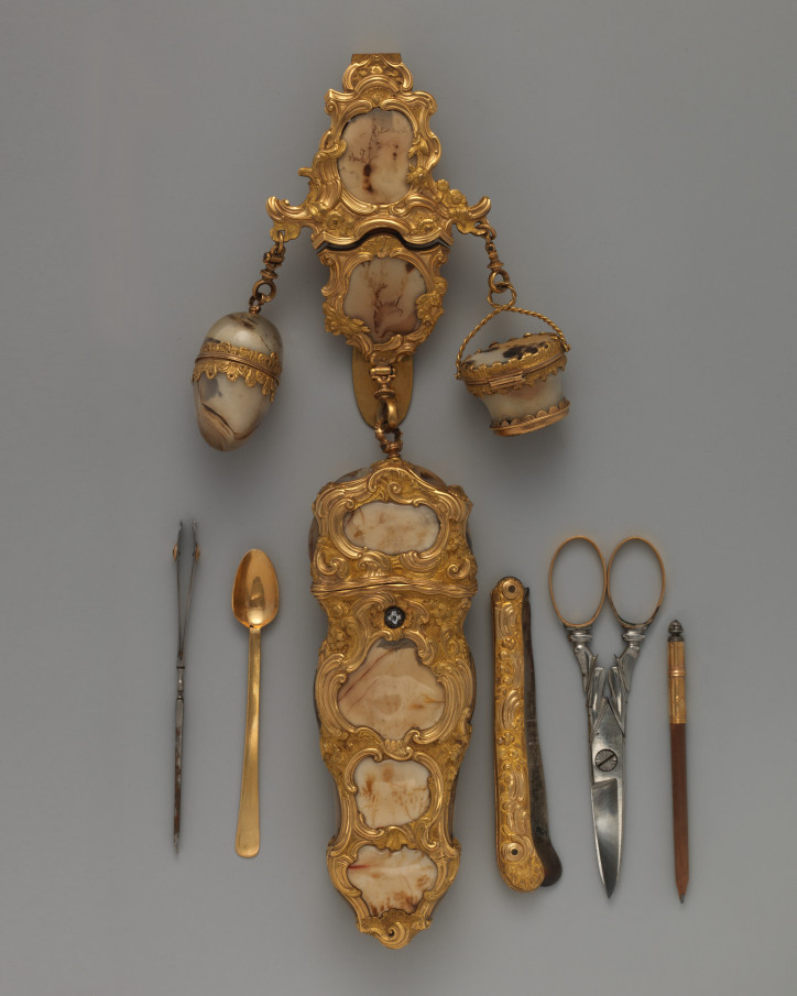 Dewizka/przybornik (chatelaine) z około 1750–60 r., wykonana ze złota, ozdobiona agatem mszystym i diamentem, w schowku: pęseta, łyżeczka, mała brzytwa, nożyczki, ołówek; zdjęcie: MET, domena publiczna 