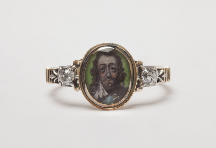 Pierścień żałobny z połowy XVIII w. upamiętniający Karola I Stuarta, ozdobiony kryształem przykrywającym portret monarchy na zielonym emaliowanym tle, osadzony pomiędzy dwoma brylantami w srebrnych oprawkach; ©Victoria & Albert Museum, London