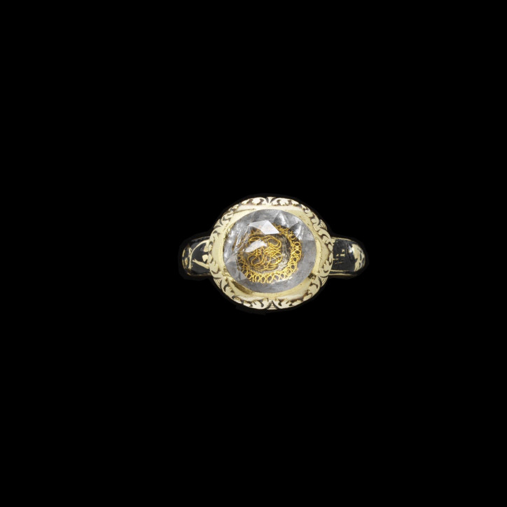 Żałobny pierścień z ok. 1709 r., wykonany ze złota, ozdobiony fasetowanym kryształem górskim przykrywającym monogram ze złotego drutu. Obrączka ozdobiona emaliowanym na czarno motywem szkieletu oraz skrzyżowanych kości, opatrzona inskrypcją po wewnętrznej stronie: „M Frend obt 9' May 1709 aeta. 59”; ©Victoria & Albert Museum, London