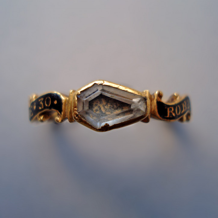 Pierścień żałobny z ok. 1743 r., wykonany ze złota, ozdobiony kryształem w kształcie trumny przykrywającym motyw czaszki i skrzyżowanych piszczeli. Obrączka ozdobiona napisem na emaliowanym na czarno tle: „ROBT.HEARD OB. JUNE.5.1743. AE.30”; © The Trustees of the British Museum CC BY-NC-SA 4.0 