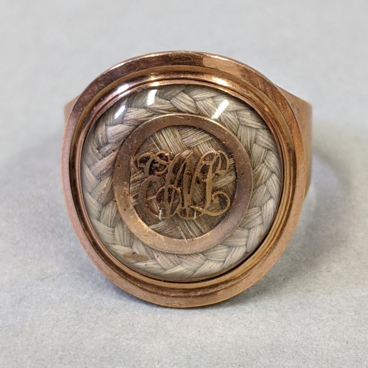 Pierścień pamiątkowy lub żałobny z 1809 r., wykonany ze złota, ozdobiony kryształem przykrywającym splecione włosy oraz inicjały EWL. Na obrączce widnieje wygrawerowana inskrypcja: „E.W.L. ob 16 May 1809 aet 9 yrs”; ©Victoria & Albert Museum, London