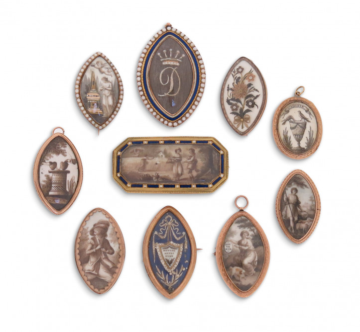 Dziesięć emaliowanych medalionów i broszek żałobnych z końca XVIII w. przedstawiających różne sceny żałobne lub ozdobionych plecionymi włosami oraz maleńkimi perłami; zdjęcie: Woolley and Wallis 