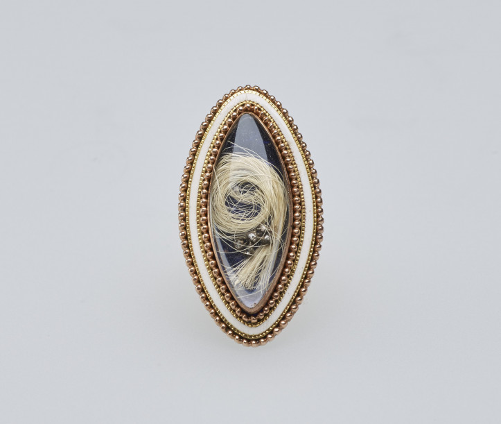 Złoty pierścionek żałobny z XVIII/XIX w., z kryształem w kształcie markizy przykrywającym pukiel włosów, przyozdobionym złotą granulacją oraz białą emalią. Pierścień poświęcony pamięci księżnej Karoliny, córki Williama Henry'ego, księcia Gloucester, zapisany w spadku królowej Wiktorii przez księżniczkę Zofię Matyldę; zdjęcie: Royal Collection Trust/© Her Majesty Queen Elizabeth II 2021