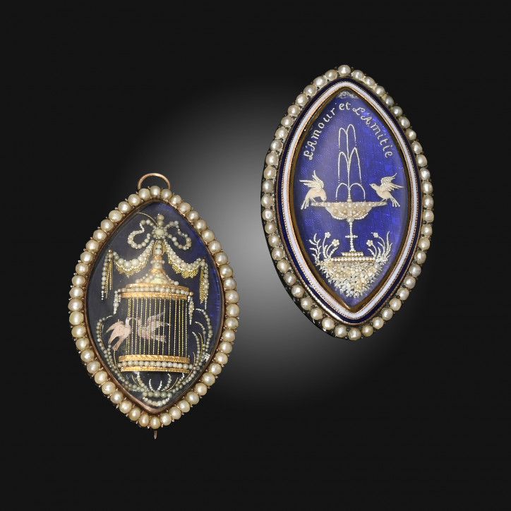 Dwa medaliony żałobne w kształcie markizy z końca XVIII w., wykonane ze złota, ozdobione niebieską emalią oraz kompozycjami z maleńkich pereł; zdjęcie: Woolley and Wallis