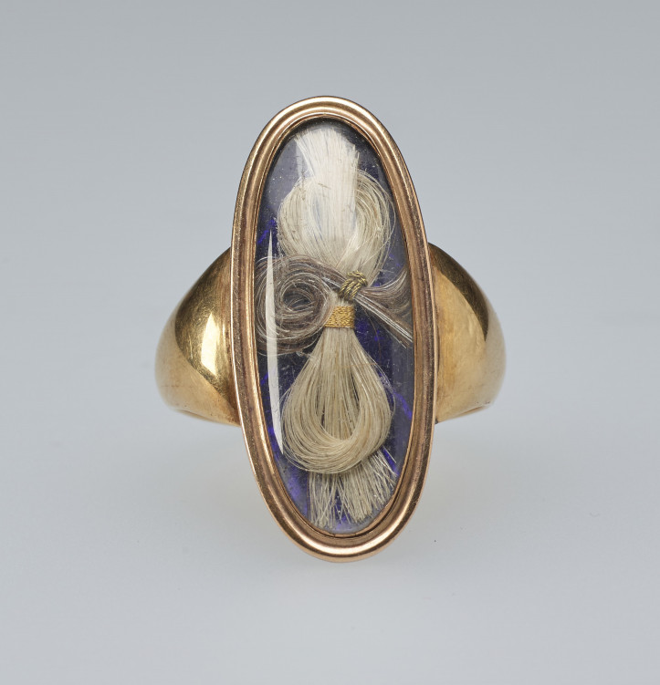 Złoty pierścionek żałobny z XVIII/XIX w., z owalnym kryształem przykrywającym dwa pukle włosów na emaliowanym na niebiesko tle. Wewnątrz pierścienia wygrawerowany pamiątkowy napis; zdjęcie: Royal Collection Trust/© Her Majesty Queen Elizabeth II 2021