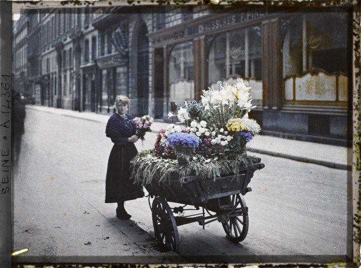 Sprzedawczyni kwiatów przed rue Cambon 53 w Paryżu, 1918 r., fot. Auguste Léon, Muzeum Alberta Kahna, domena publiczna